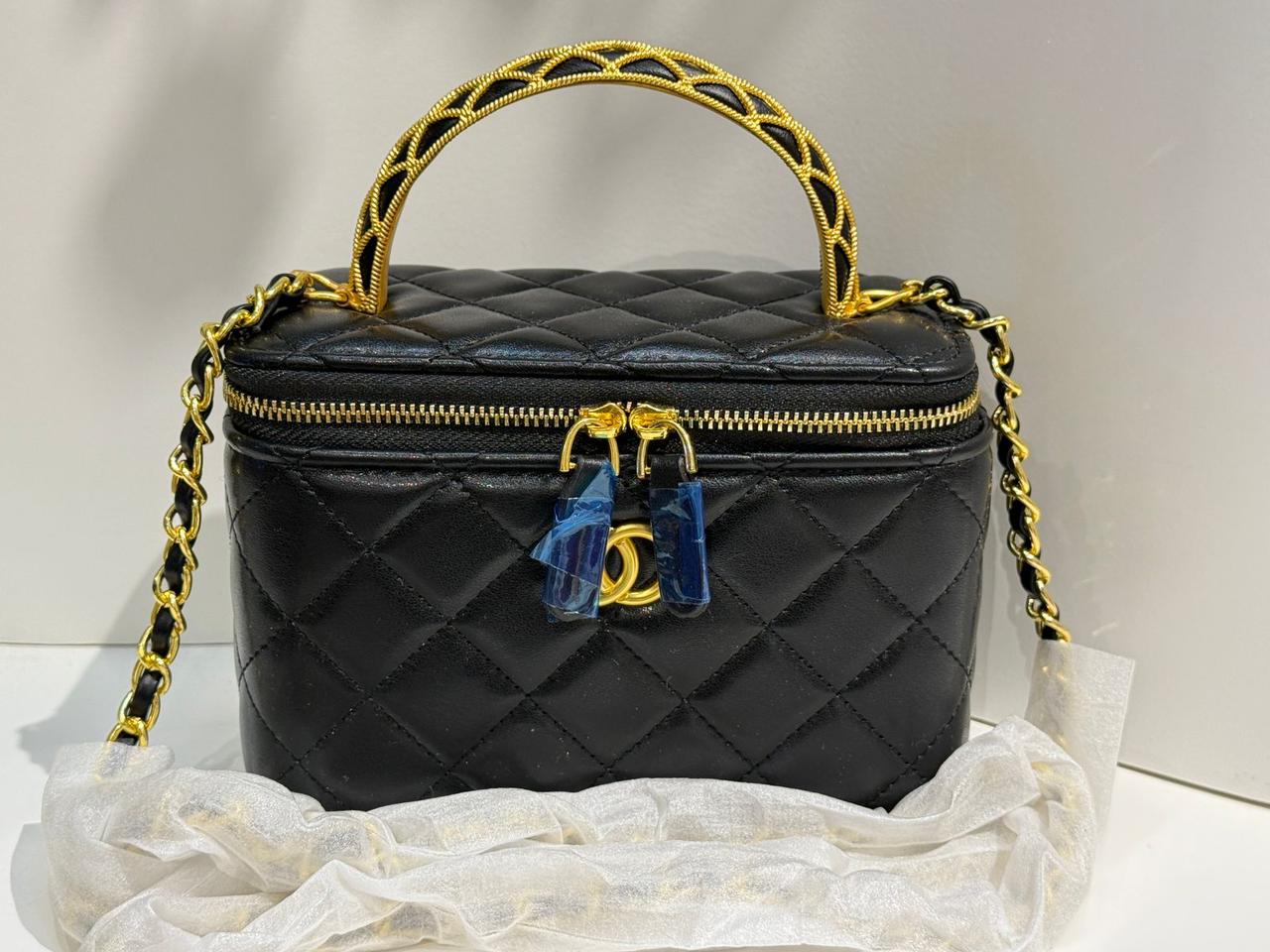 Black quilted handbag with gold handle